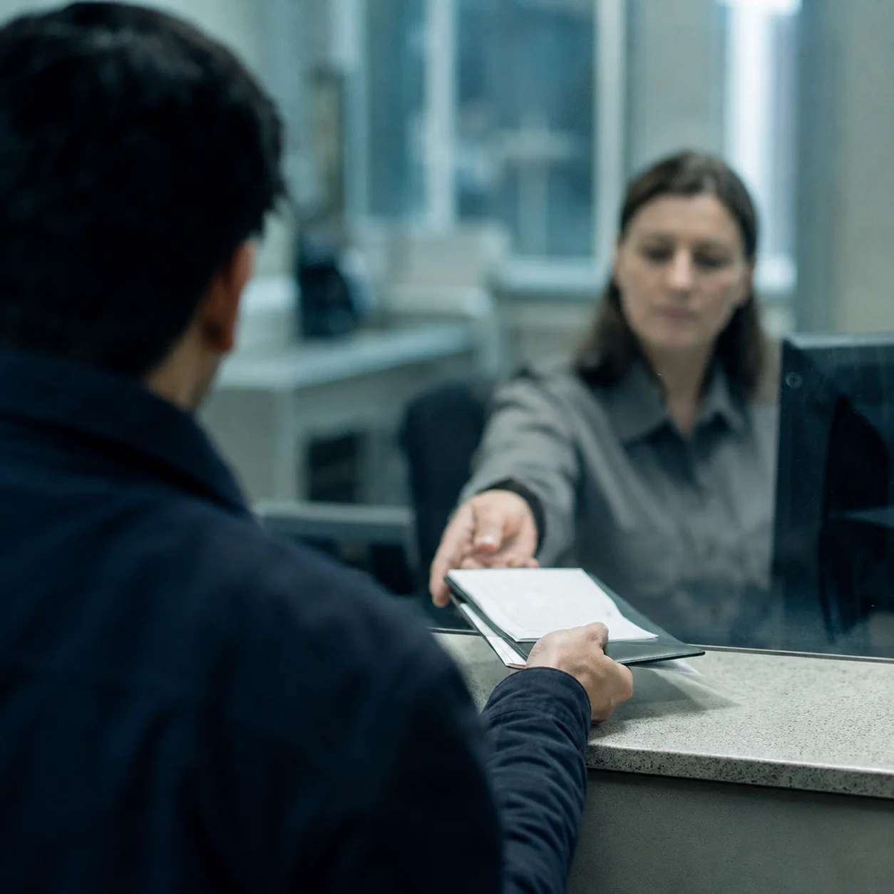 Persona recibiendo su visado en una oficina consular